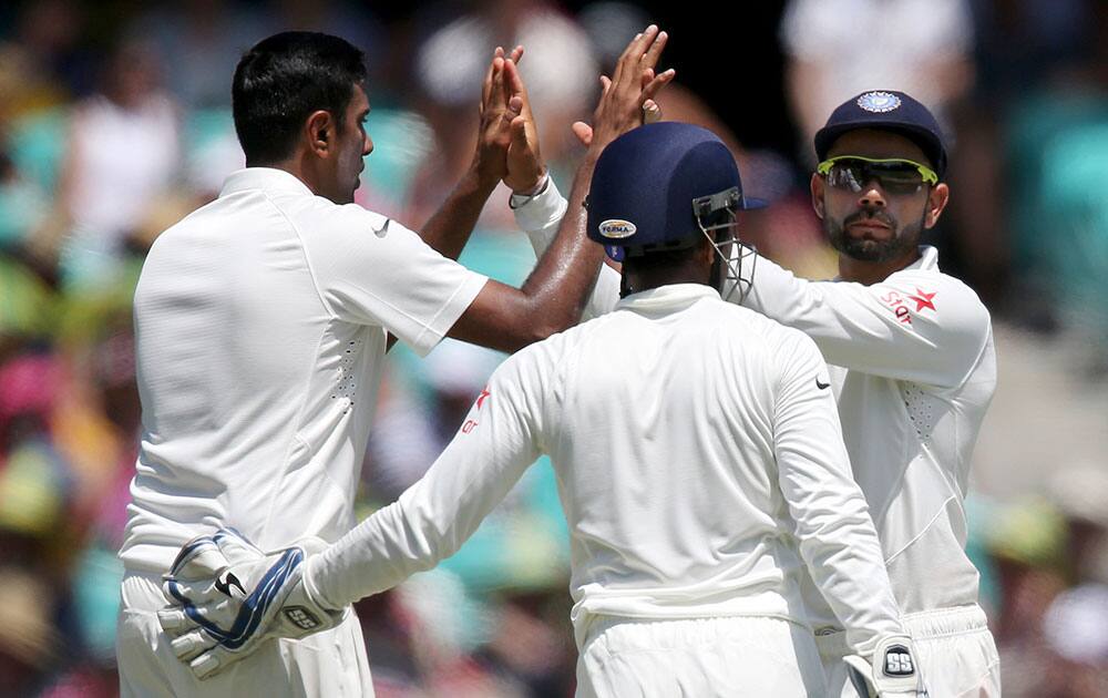 India's Ravichandran Ashwin is congratulated by teammates after he dismissed Australia's David Warner for 101 runs during their cricket test match in Sydney.