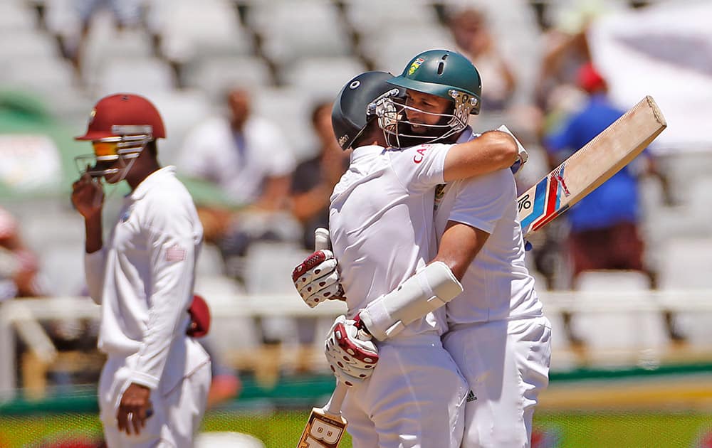 South African Dean Elgar, hugs Hashim Amla, as they win against the West Indies during the third test game in Cape Town, South Africa.