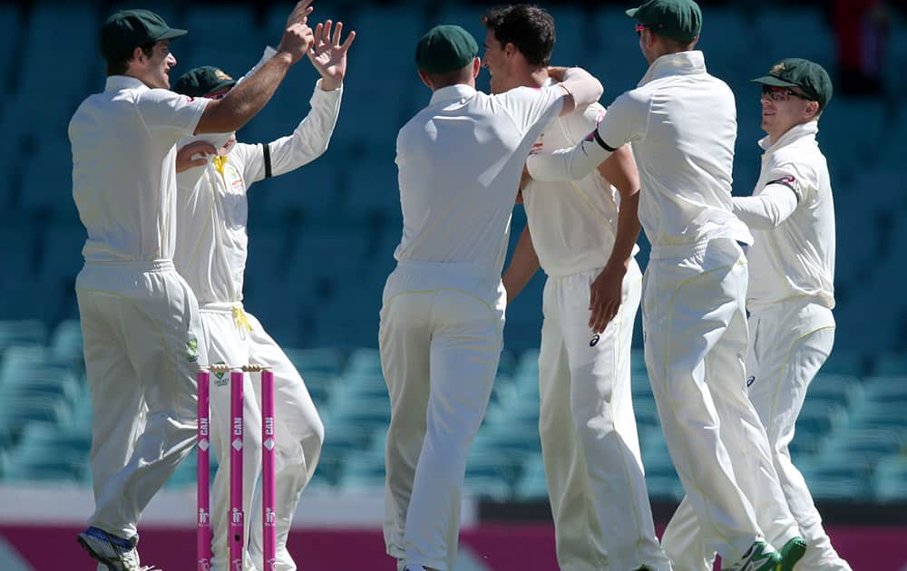 Australian teammates celebrate with Australia's Mitchell Starc, after he dismissed India's Murali Vijay for no score on the second day of their cricket test match in Sydney.