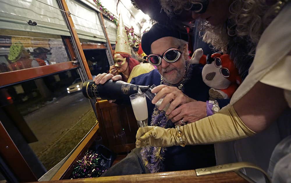 Members of the Phunny Phorty Phellows, pour champagne during their night of revelry aboard a streetcar in New Orleans. King's Day is a tradition marking the 12th night after Christmas and the official start of the Mardi season.