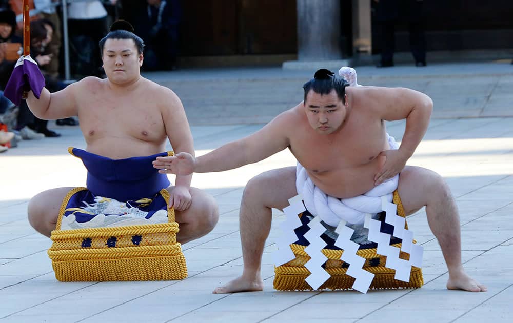 Sumo grand champion Kakuryu, of Mongolia performs his ring entry forms to dedicate to the Meiji Shrine in Tokyo.