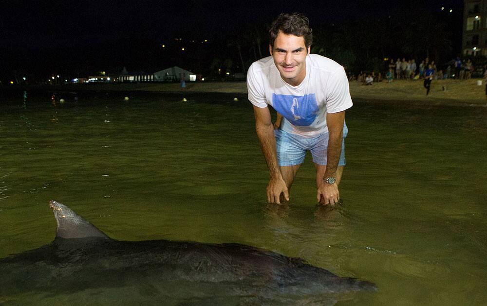 This photo provided by Tennis Photo Network, Roger Federer of Switzerland poses with a dolphin at the Tangalooma Resort on Moreton Island during the Brisbane International tennis tournament in in Brisbane, Australia.