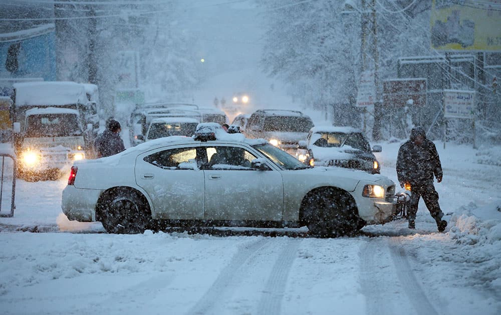 A Lebanese police car blocks a main road that links to Beirut, after the mountain roads were blocked by the snow, in Chtoura town, in the Bekaa valley, east Lebanon.
