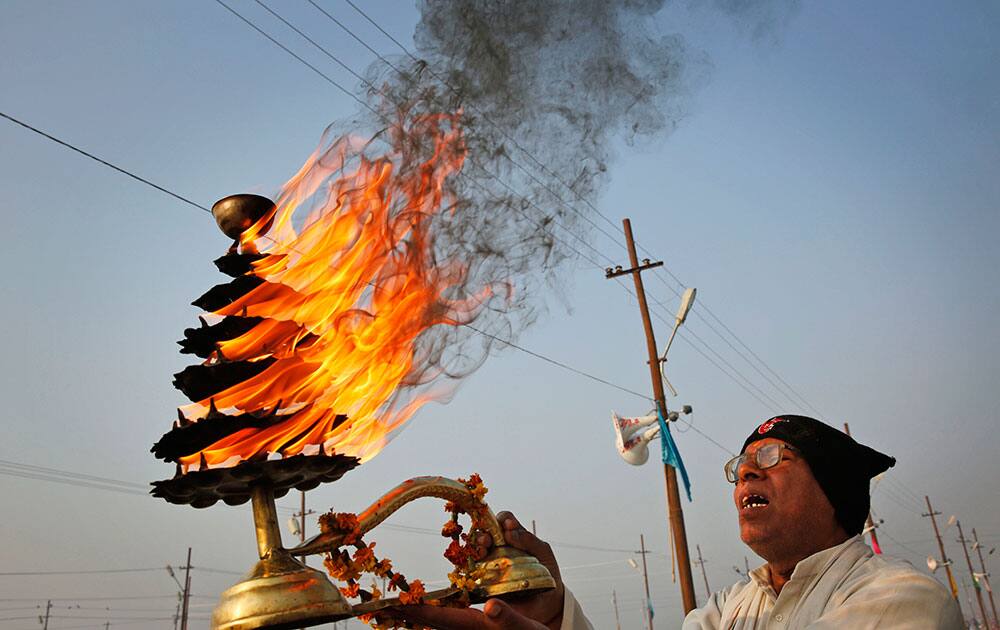 An Indian Hindu priest rotates an oil lamp as he performs rituals at