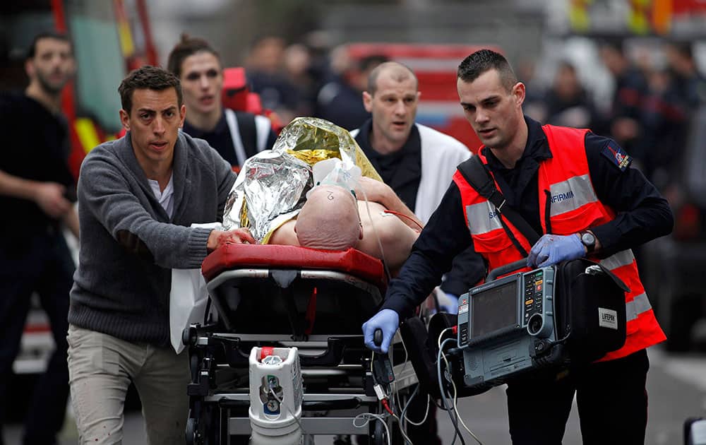 An injured person is evacuated outside the French satirical newspaper Charlie Hebdo's office, in Paris.