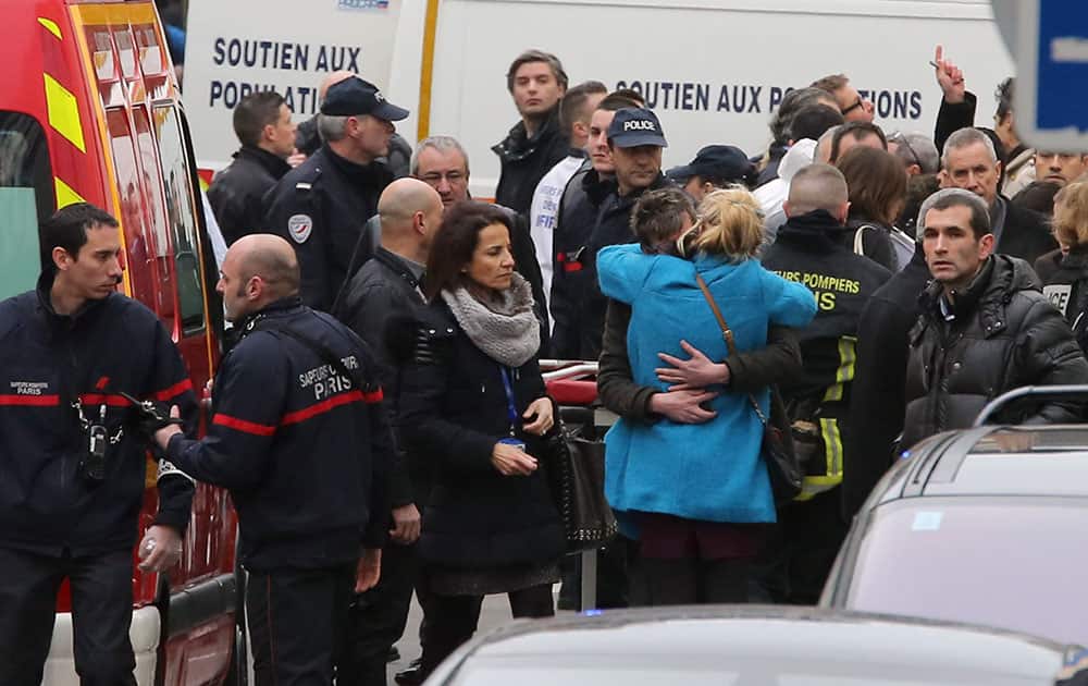 People hug each other outside the French satirical newspaper Charlie Hebdo's office, in Paris.