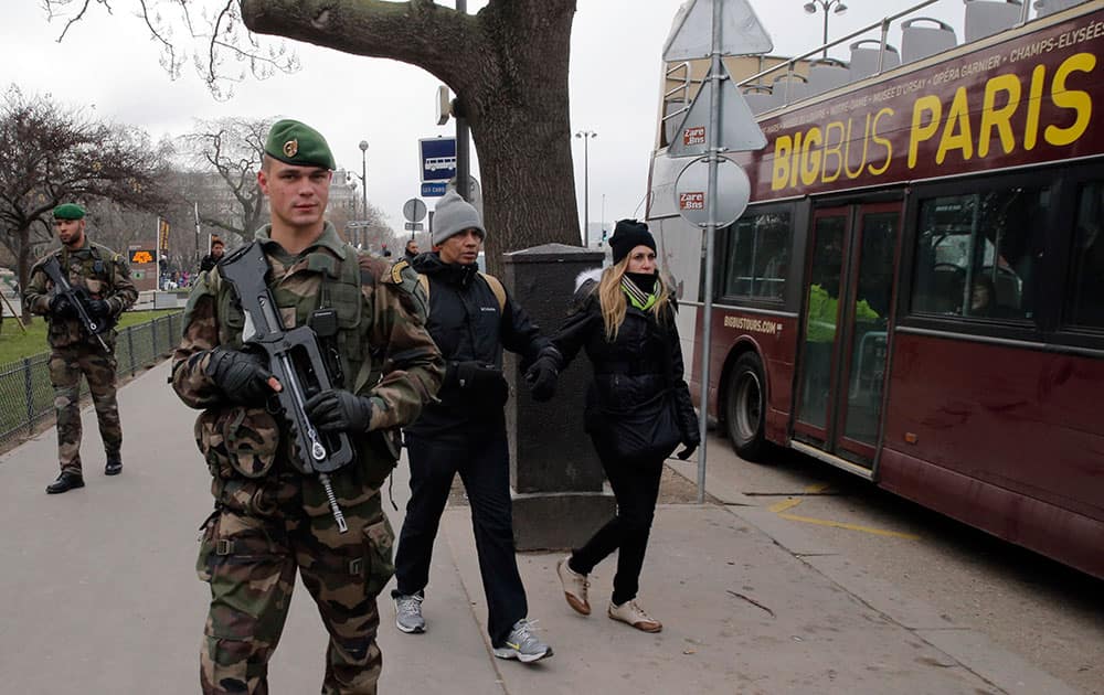 French soldiers patrols next to the Eiffel Tower after a shooting at a French satirical newspaper, in Paris.