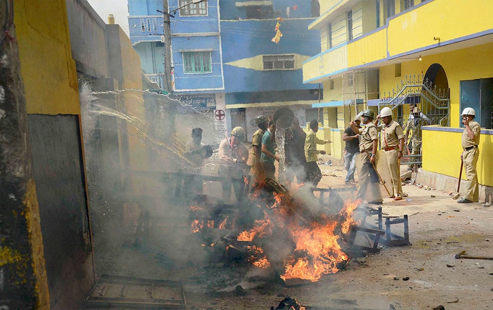 Police trying to douse the burnt vehicles after agitating parents and locals pelted stones and vandalized the school where a teacher allegedly molested an 8-year old girl in Bengaluru.