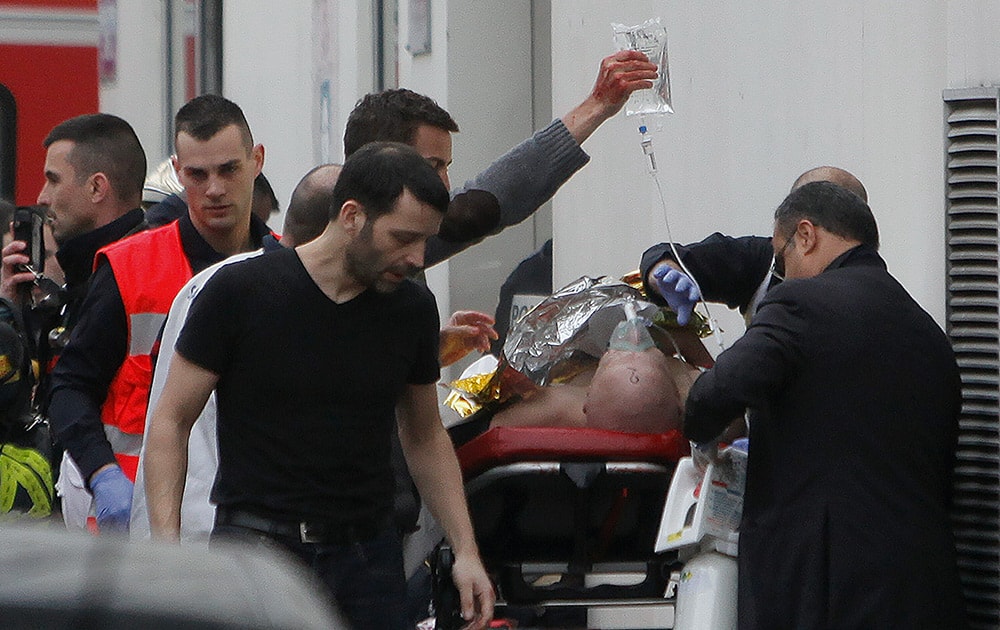An injured person is transported to an ambulance after a shooting, at the French satirical newspaper Charlie Hebdo's office, in Paris.