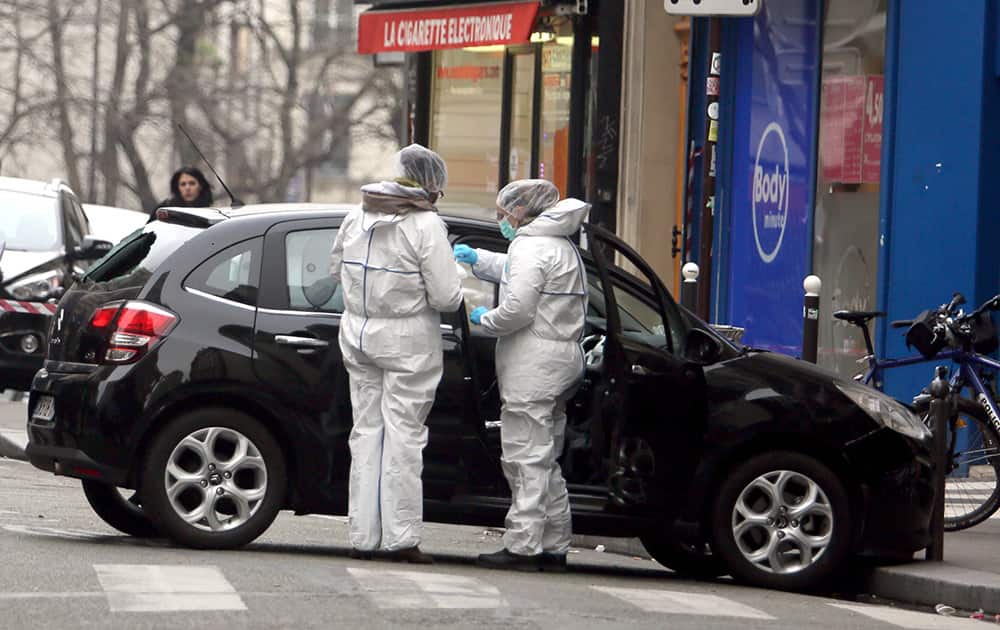 Forensic experts examine the car believed to have been used as the escape vehicle by gunmen who attacked the French satirical newspaper Charlie Hebdo's office, in Paris, France.