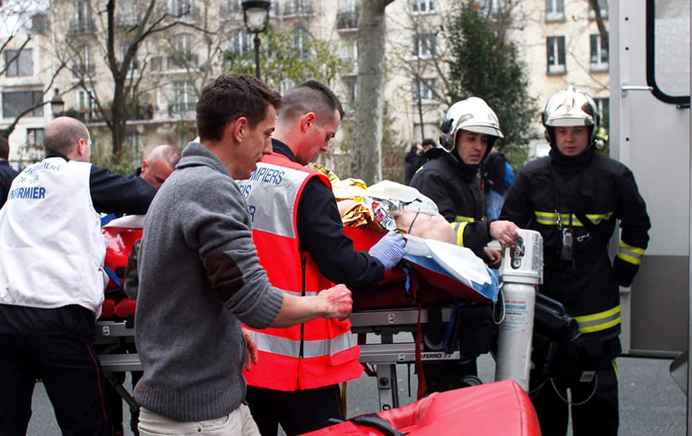 An injured person is carried into an ambulance after a shooting, at the French satirical newspaper Charlie Hebdo's office, in Paris.