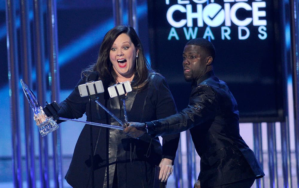 Kevin Hart, right, films Melissa McCarthy as she accepts the award for favorite comedic movie actress at the People's Choice Awards at the Nokia Theatre.