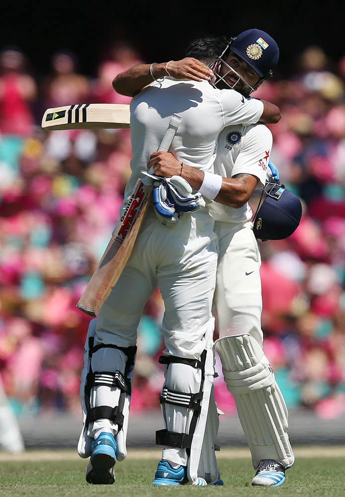 India's Lokesh Rahul, left, celebrates with his captain Virat Kohli after making 100 runs against Australia on the third day of their cricket test match in Sydney.