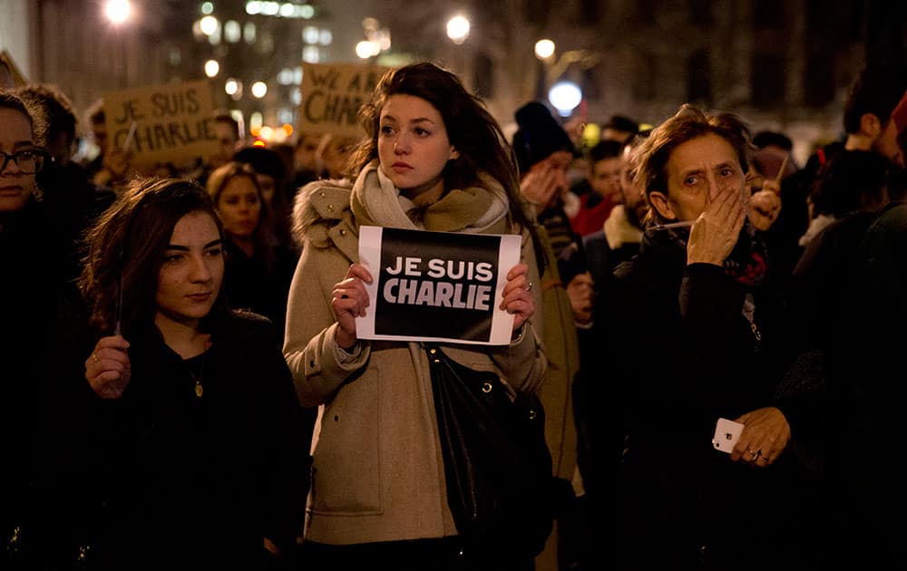 People hold up pens and posters reading 'I am Charlie' in French as they take part in a vigil of people, including many who were French, to show solidarity with those killed in an attack at the Paris offices of weekly newspaper Charlie Hebdo, in Trafalgar Square, London.