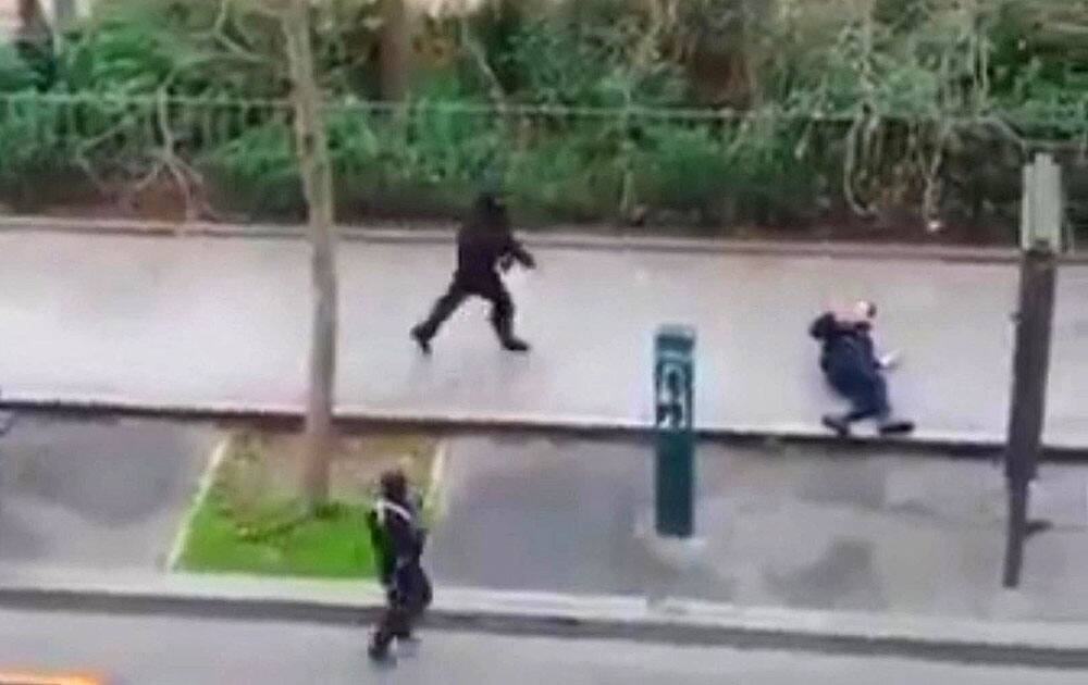 Masked gunman run towards a victim of their gun fire outside the French satirical newspaper Charlie Hebdo's office, in Paris.