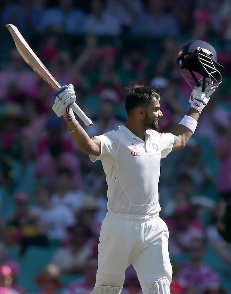India's Virat Kohli raises his bat after making 100 runs against Australia on the third day of their cricket test match in Sydney.