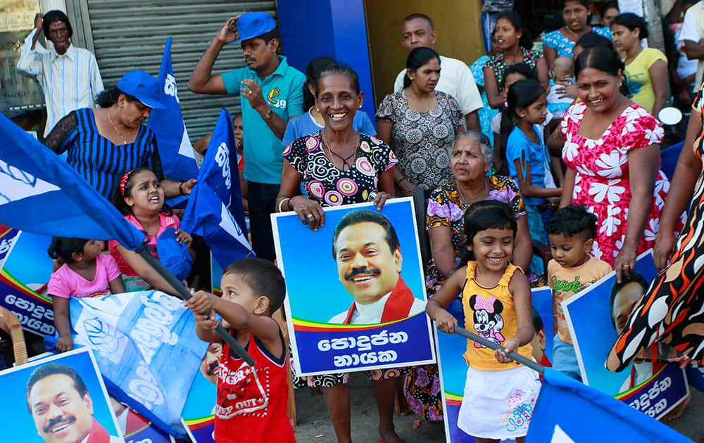 A Supporter holds a poster of Sri Lankan president Mahinda Rajapaksa as she celebrates at the end of voting in the presidential election in Colombo, Sri Lanka.