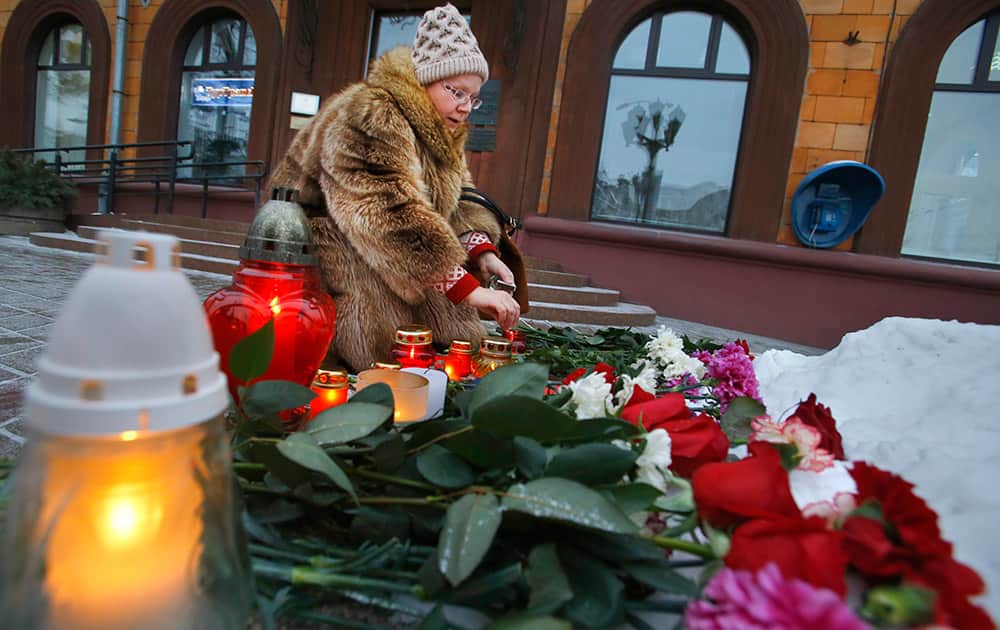 A woman lights a candle outside the French Embassy in Minsk, Belarus. French President Francois Hollande says the country has been 