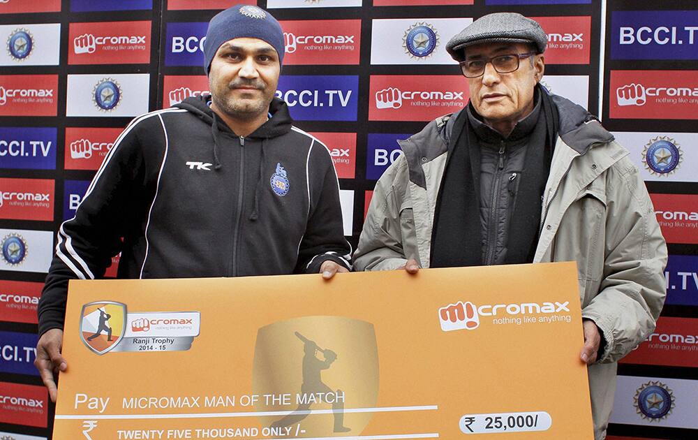 Cricketer Virendra Sehwag being given man of the match award by former BCCI President Ranbir Singh Mahendra after a cricket match in Rohtak.