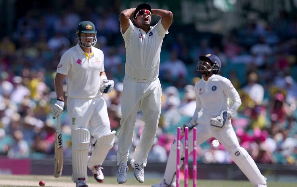 Suresh Raina and Wriddhiman Saha,, react to a missed stumping chance on Australia's Shane Watson, left, on the fourth day of their cricket test match in Sydney.