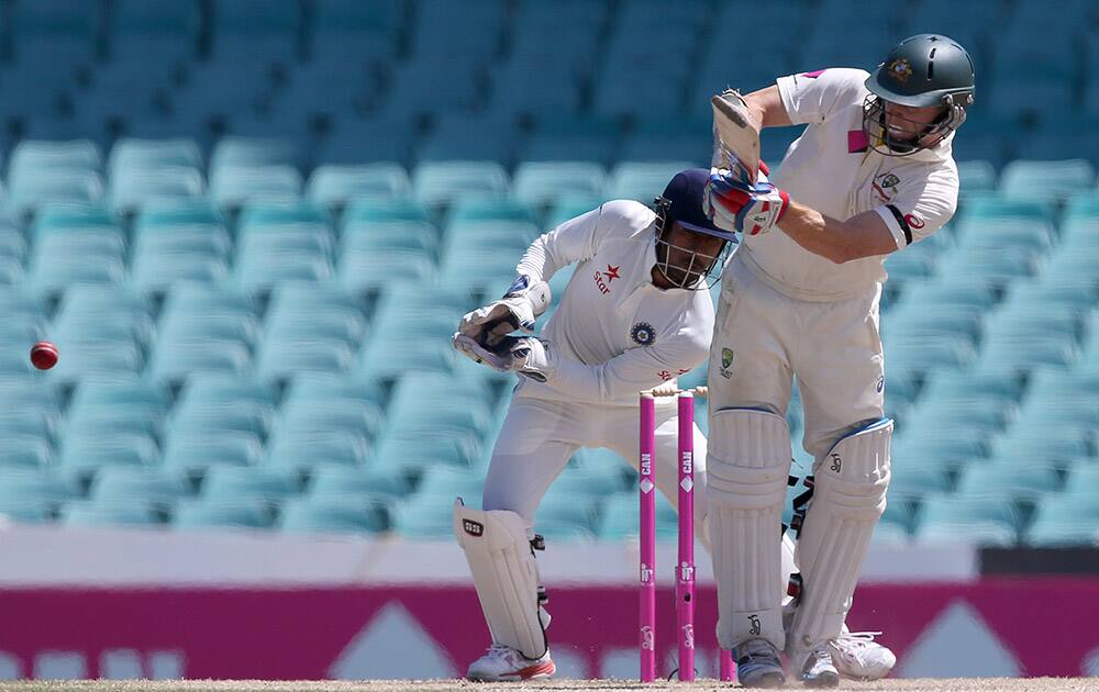 Australia's Chris Rogers, pulls the ball in front of India's Wriddhiman Saha on the fourth day of their cricket test match in Sydney.