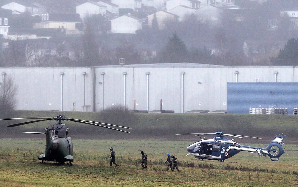 Police and army forces take positions in Dammartin-en-Goele, northeast Paris, as part of an operation to seize two heavily armed suspects. French security forces swarmed a small industrial town northeast of Paris Friday in an operation to capture a pair of heavily armed suspects in the deadly storming of a satirical newspaper.