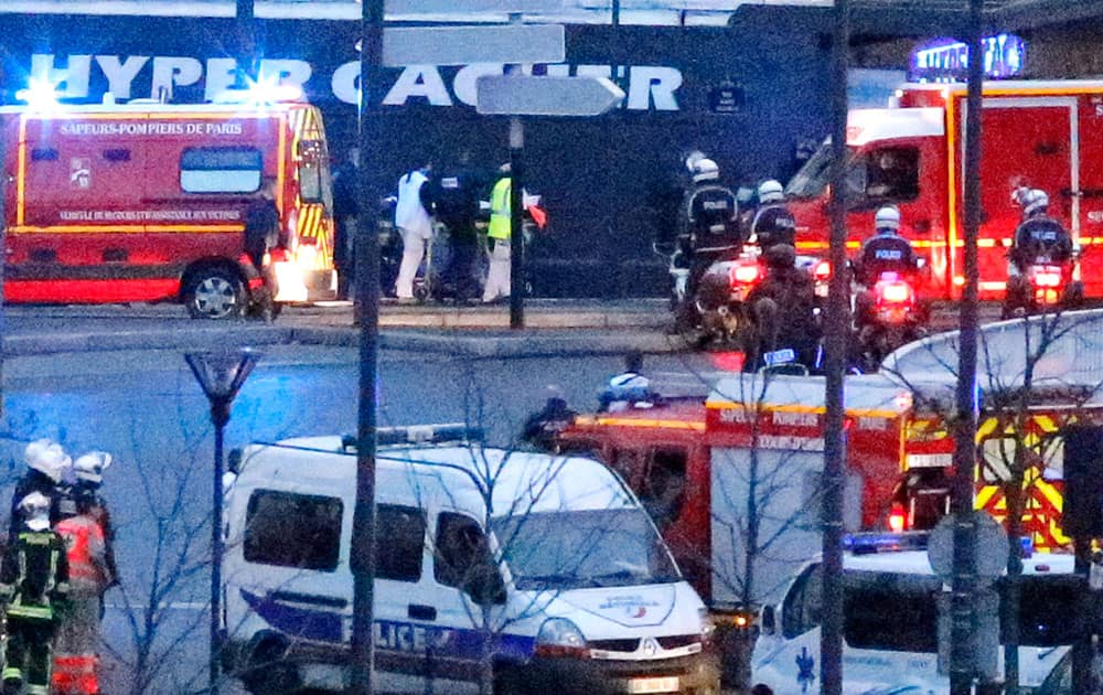 Rescue workers enter after police forces stormed the kosher store where a gunman held several hostages, in Paris.