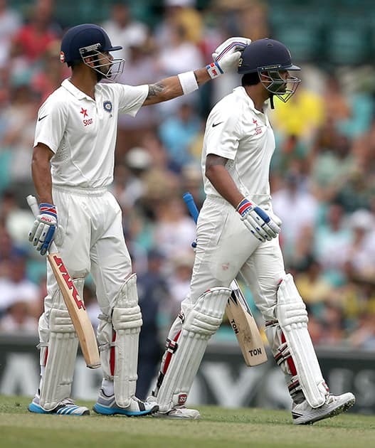 Murali Vijay, gets a pat on his head from his captain Virat Kohli after he was caught behind for 80 runs on the fifth day of their cricket test match in Sydney.