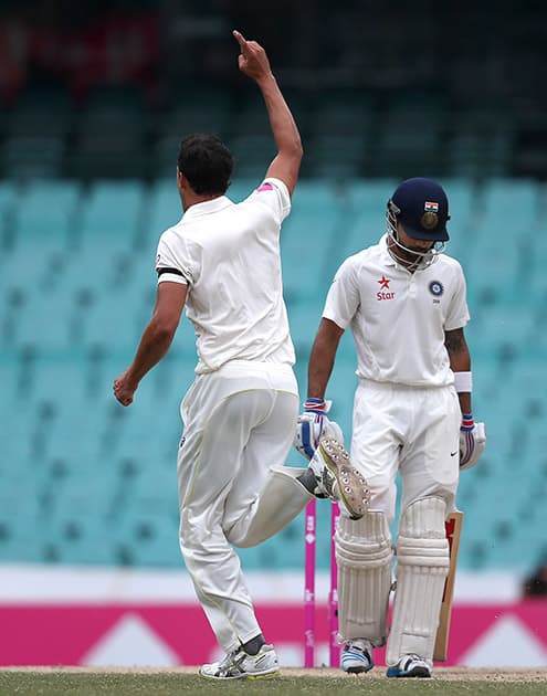 Virat Kohli lowers his head after he lost his wicket to Australia's Mitchell Starc, on the fifth day of their cricket test match in Sydney.