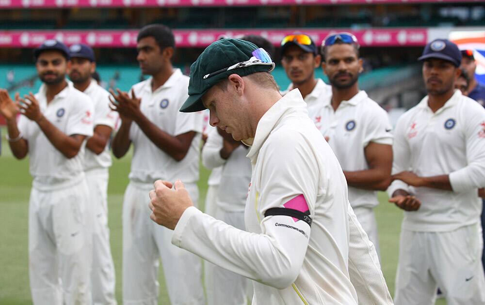 Indian players applaud Australia's Steve Smith, as he is named man of the match and of the series on the fifth day of their cricket test match in Sydney.