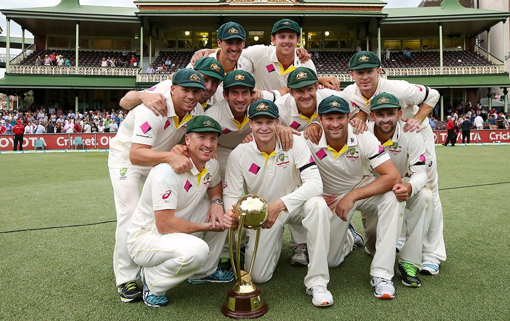 The Australian team players pose with the Border/Gavaskar trophy after defeating India on the fifth day of their cricket test match in Sydney.