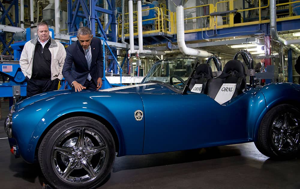 Tom Drye, Managing Director of Techmer ES watches as President Barack Obama touches a 3D printed Shelby Cobra at Techmer PM, a plastic fabrication company in Clinton, Tenn., where the president talked about the administration's efforts to create new, good paying manufacturing jobs.