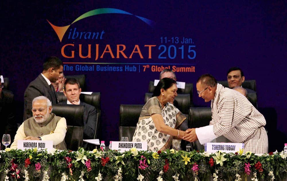 Prime Minister Narendra Modi looks on as Bhutan PM Tshering Tobgay shakes hands with Gujarat CM Anandiben Patel at Vibrant Gujarat Global Summit 2015 in Gandhinagar.
