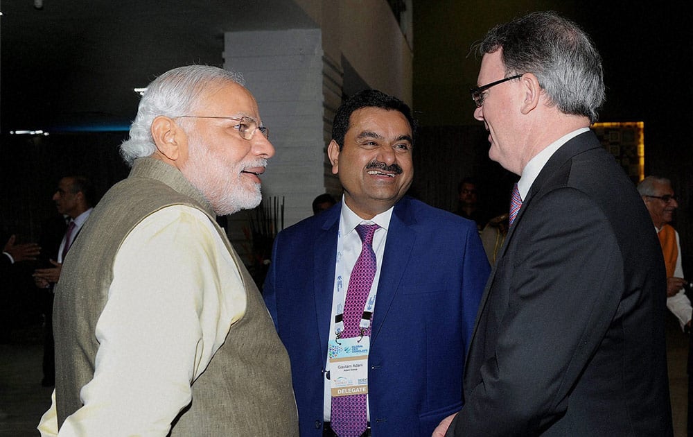 Prime Minister, Narendra Modi with industrialist Gautam Adani and a foreign delegate at the Mahatma Mandir premises during the Vibrant Gujarat Global Summit 2015 in Gandhinagar.