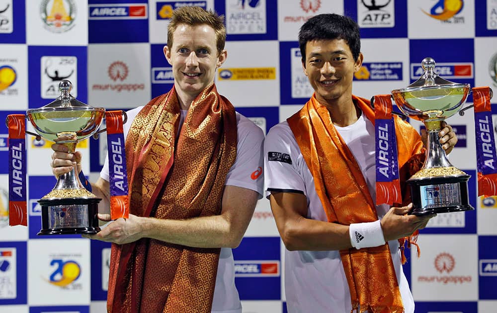 Jonathan Marray of Britain, left, and Lu Yen-hsun of Chinese Taipei hold their trophies after winning the doubles final match against India's Leander Paes and South Africa's Raven Klaasen at the ATP Chennai Open 2015.