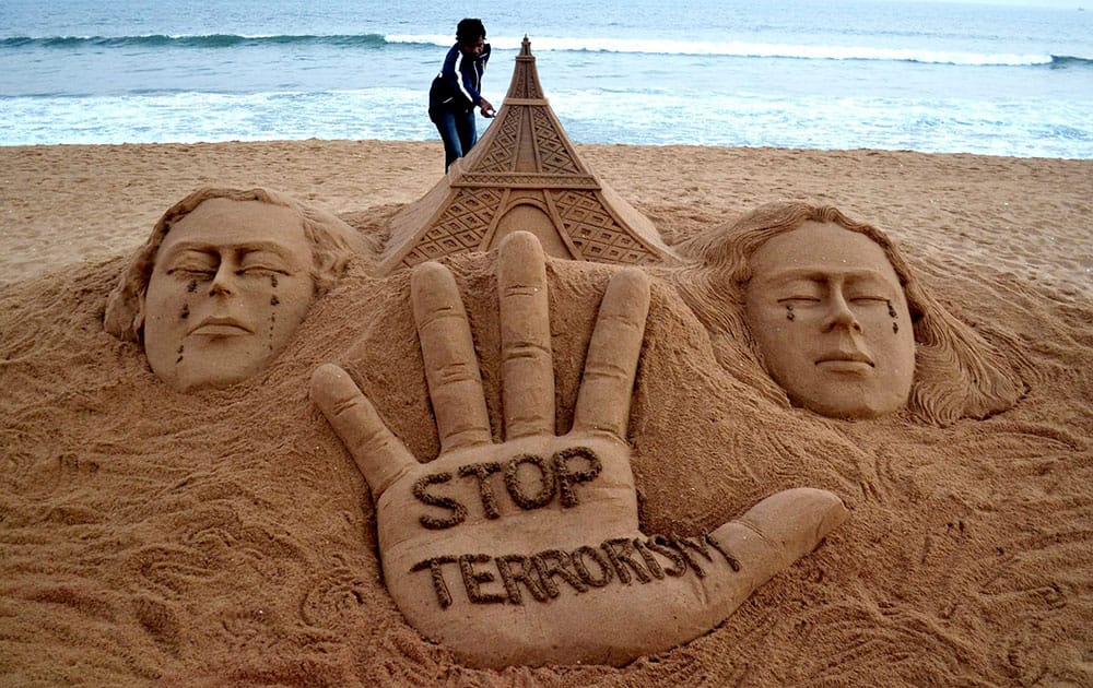 Sand artist Sudarsan Pattnaik creates a Sand Sculpture of Eiffel Tower with a message Stop Terrorism to condemn the terrorist attack a media office in Paris, at Puri beach of Odisha.