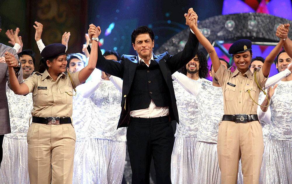 Bollywood actor Shah Rukh Khan with police women perform during the Umang Mumbai Police Show 2015 in Mumbai.