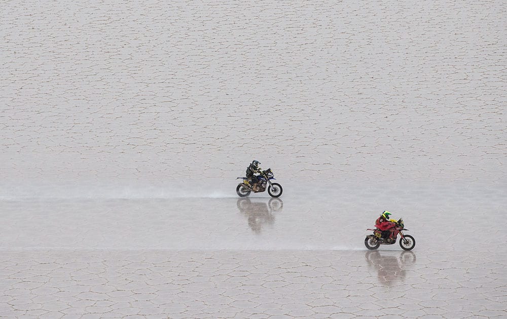 Honda rider Jean de Azevedo of Brazil, right, leads Yamaha rider Michael Metge of France, as they race across the Uyuni salt flat during the eighth stage of the Dakar Rally 2015 between Uyuni, Bolivia, and Iquique, Chile.