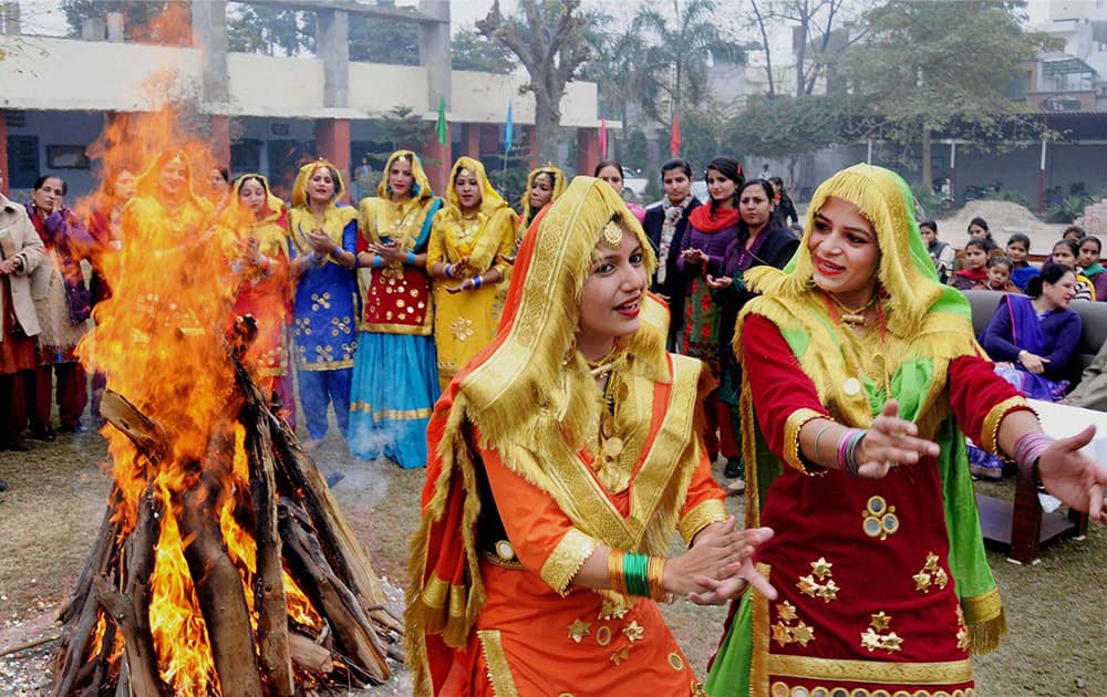 Attired in traditional dress, college girls perform gidha (popular folk dance of women in Punjab) around a bonfire as they celebrate Lohri Festival.