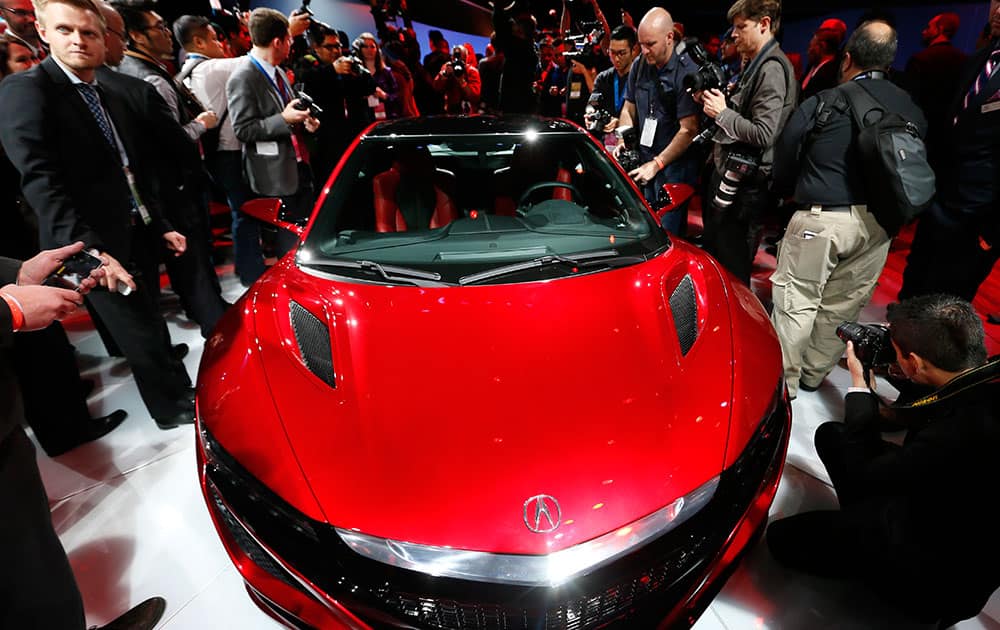 media surround the Acura NSX at its debut during media previews for the North American International Auto Show in Detroit. The NSX, due in showrooms this summer, is expected to cost around $150,000.