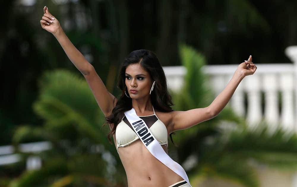 Miss Universe contestant Noyonita Lodh, of India, walks along the pool during the Yamamay swimsuit runway show.