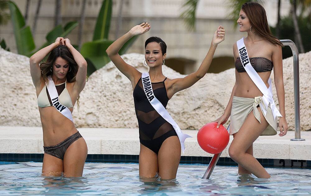 Miss Universe contestants Valentina Bonariva, of Italy, left, Kaci Fennell, of Jamaica, and Doron Matalon, of Israel, dance in the water during the Yamamay swimsuit runway show.