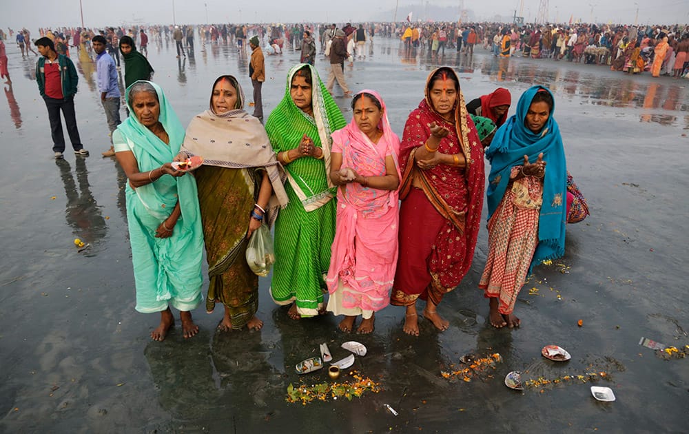 Hindu pilgrims offer prayers to the Sun God after taking holy dips to mark Makar Sankranti festival in Gangasagar.