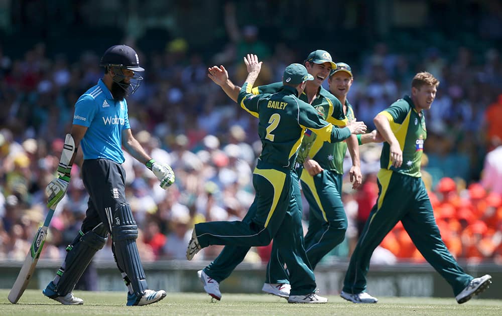 Australia's James Faulkner, celebrates with teammates after taking the wicket of England's Moeen Ali, left, for 22 runs during their One Day International cricket match in Sydney.