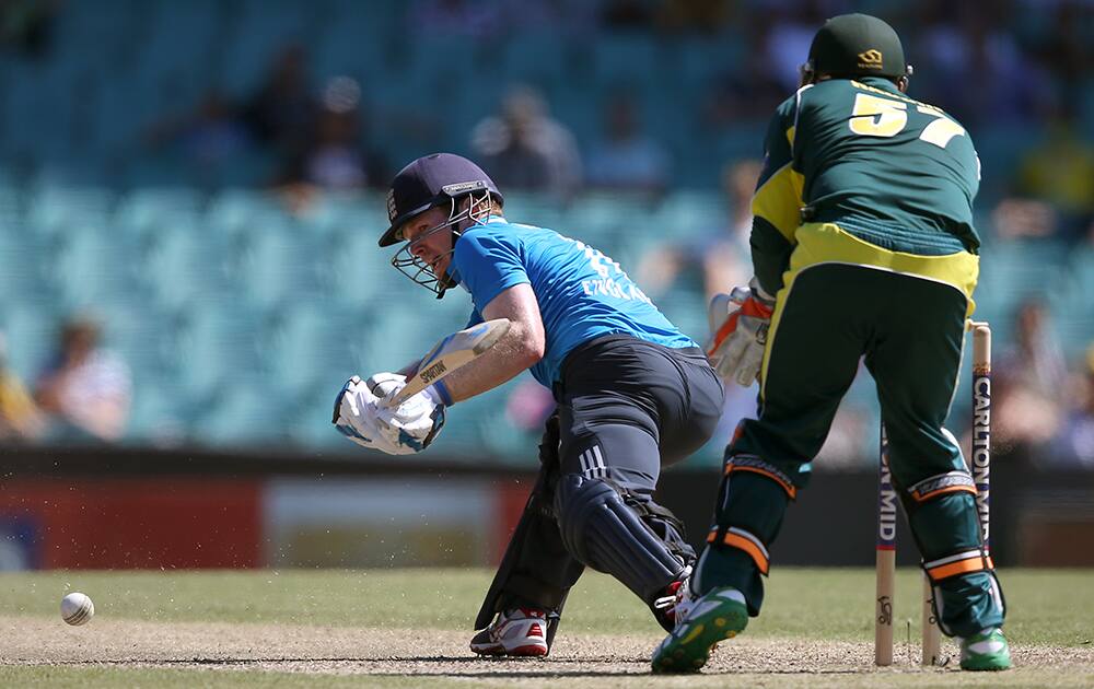 England's Eoin Morgan, plays a reverse sweep in front of Australia's Brad Haddin during their One Day International cricket match in Sydney.