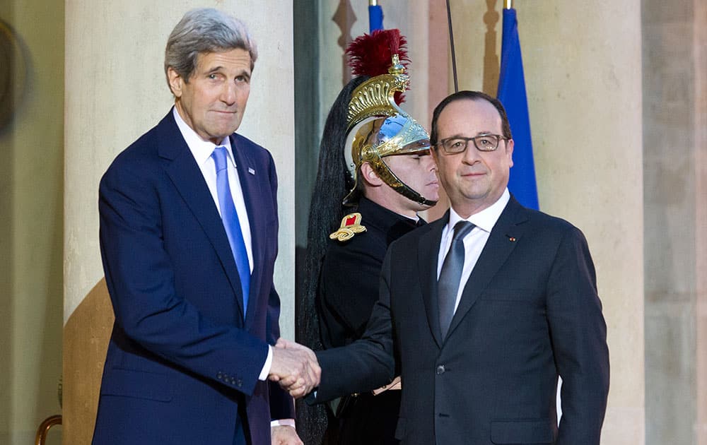 France's President Francois Hollande, right, welcomes U.S. Secretary of State John Kerry, at the Elysee Palace in Paris.