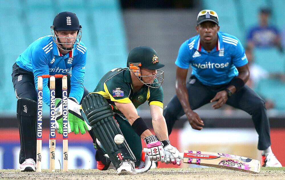 Australia's David Warner, attempts a reverse sweep in front of England's Jos Buttler, during their One Day International cricket match in Sydney.