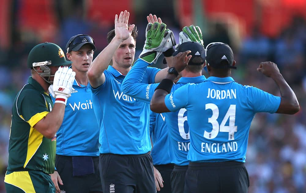 Englands Chris Woakes, celebrates with teammates after bowling out Australia's Arron Finch, for 15 runs during their One Day International cricket match in Sydney.