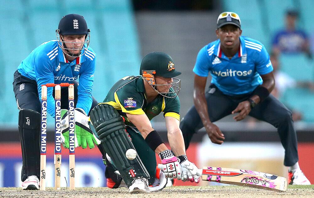 Australia's David Warner, attempts a reverse sweep in front of England's Jos Buttler, during their One Day International cricket match in Sydney.