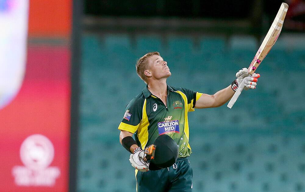 Australia's David Warner celebrates making 100 runs against England during their One Day International cricket match in Sydney.